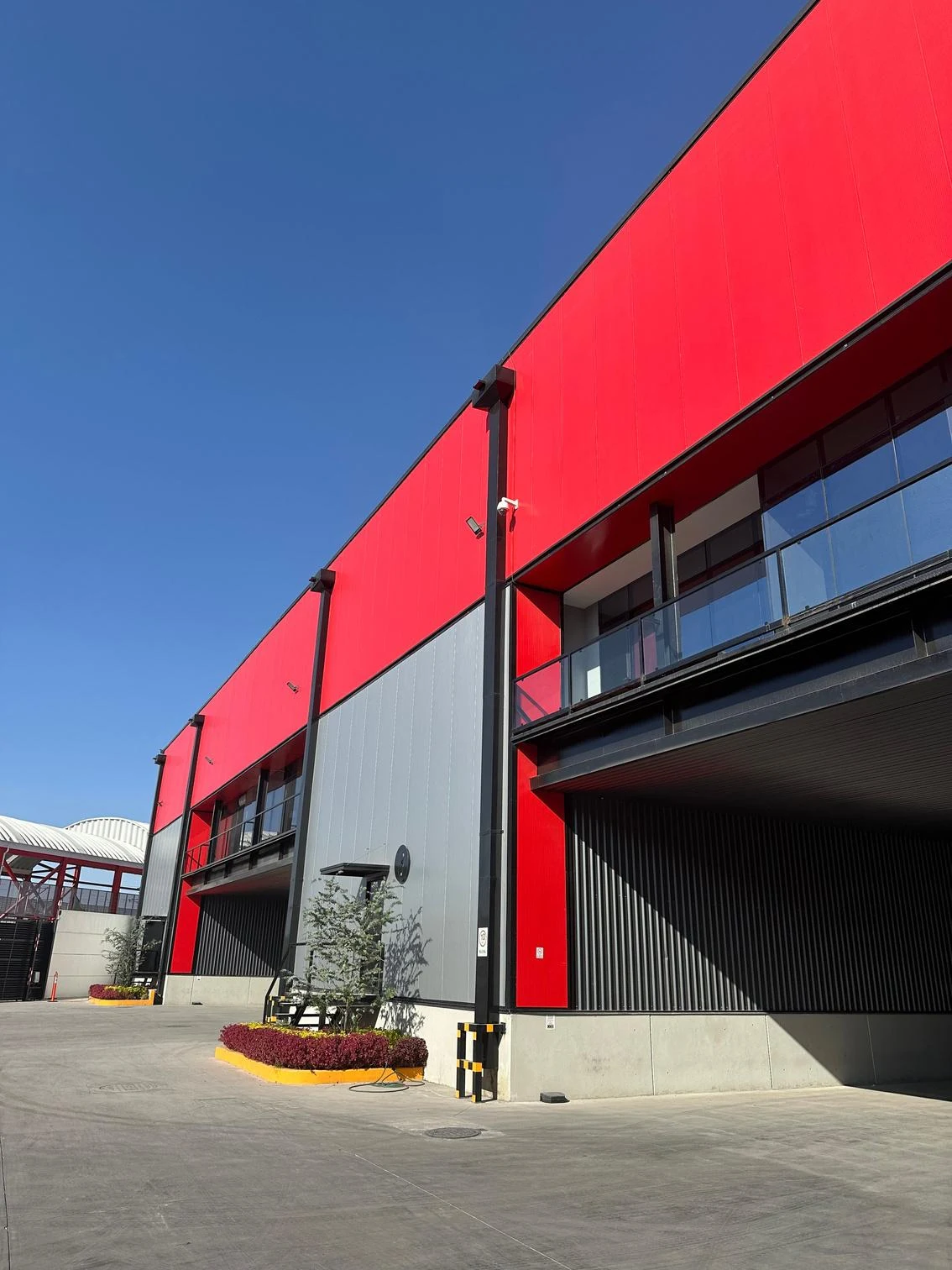 Exterior del centro de distribución con fachada roja y andenes de carga